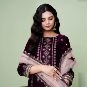 Portrait of a young woman in an embroidered dress with traditional South Asian jewelry.